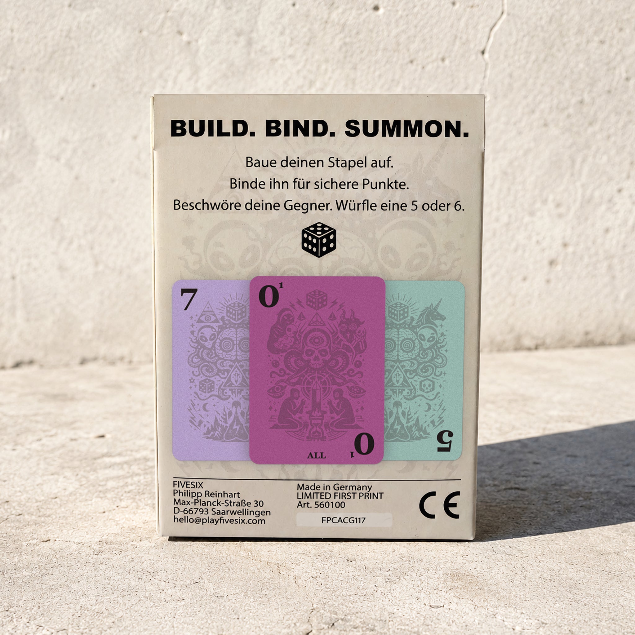 Rückseite der FIVESIX-Spielbox mit Spielprinzip Build, Bind und Summon sowie farbigen Spielkarten